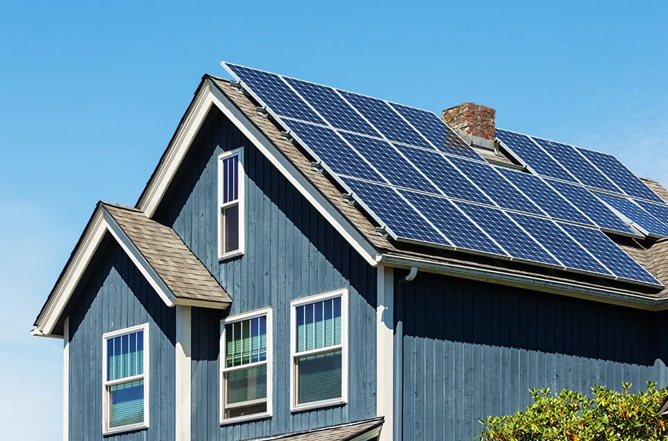 solar panels on top of a big blue barn house