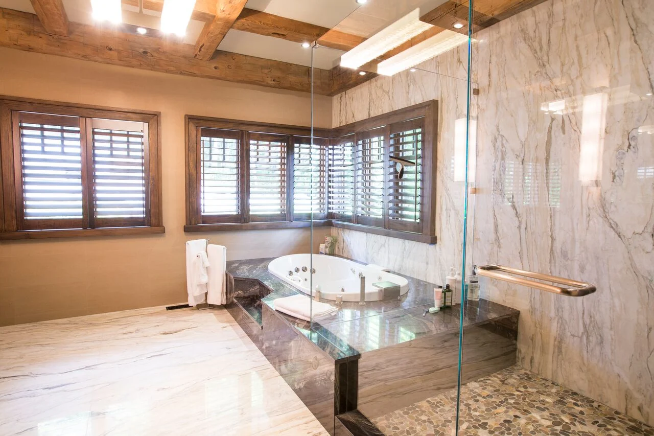 A wood-pannelled bathroom with a shower featuring glass curtains.