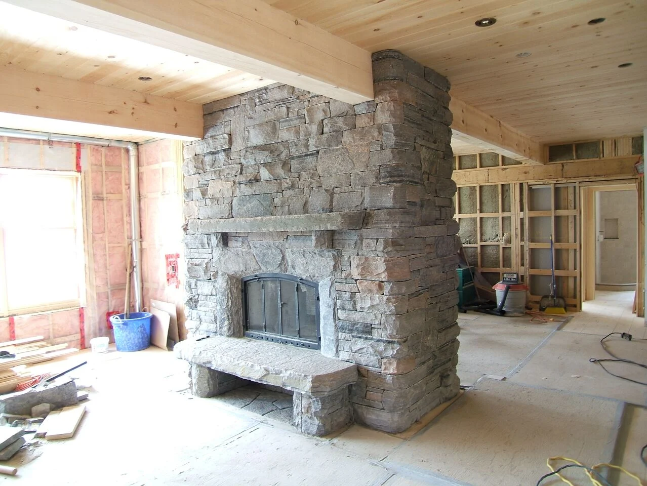 A home renovation with a new stone fireplace being installed in a completely remodelled living room.