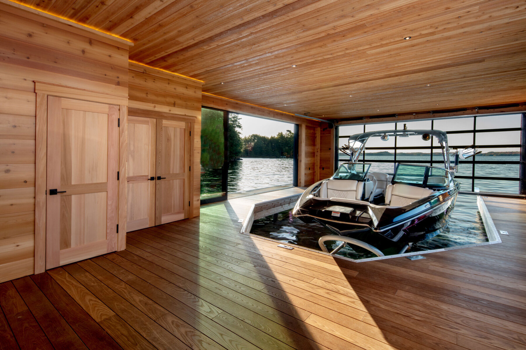Wood-paneled boathouse with boat docked inside, custom boathouse in Muskoka