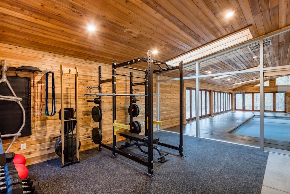Gym area beside the pool room separated by full glass walls.